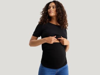 Modern maternity fashion: a pregnant woman wearing a belly band under her T-shirt.