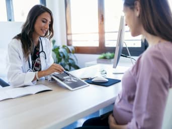 Visitas rutinarias durante el embarazo: una mujer embarazada habla con su ginecóloga