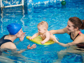 Una mamma con il suo bambino durante un corso di nuoto neonatale.