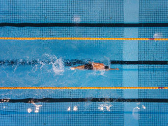 Korzyści z pływania: mężczyzna trenuje pływanie na basenie.