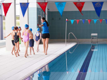 Schwimmabzeichen: Kinder mit ihrer Trainerin beim Schwimmkurs im Hallenbad.