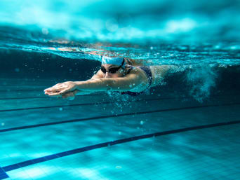 Zwemmen als sport – Zwemmer duikt in het water van het wedstrijdbad.