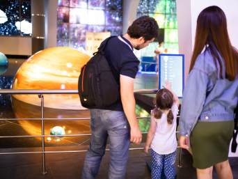 Astronomia per bambini: famiglia in visita a un planetario.