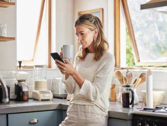 Fake Bilder erkennen: Frau liest Nachrichten auf ihrem Smartphone.