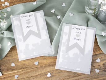Cartes d’invitation aux 25 ans de mariage : invitations aux noces d’argent faite maison avec des cœurs en confettis.
