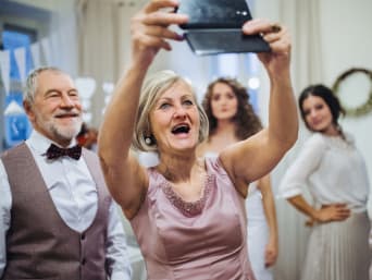 Zilveren huwelijksoutfit: feestvierders neemt samen een selfie.