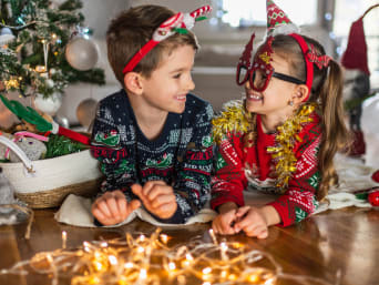 Silvester mit Kindern feiern: Zwei Geschwister in festlichen Partyoutfits für Silvester. 