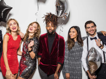 New Year's Eve outfits for men and women: a group of smartly dressed party guests.