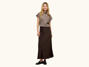Women’s New Year's Eve outfits: woman in a satin blouse and skirt. Women’s New Year's Eve outfits: woman in a satin blouse and skirt.