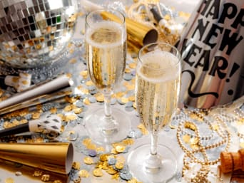 Décoration classique pour le Nouvel An : deux verres dans une déco de table noir, or et argenté.