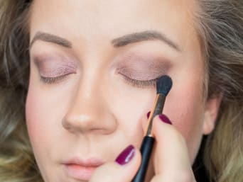 Make-up du Nouvel An : utiliser une ombre à paupières foncée pour le maquillage des yeux.