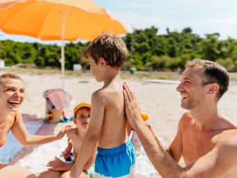 Ochrona przeciwsłoneczna dla dzieci – chłopiec w odzieży chroniącej przed promieniowaniem UV
