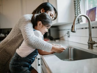 Oszczędzanie wody – mama i córka zakręciły kran podczas mycia rąk.