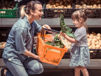 Geld sparen beim Einkaufen: Mutter und Tochter kaufen saisonales Gemüse.