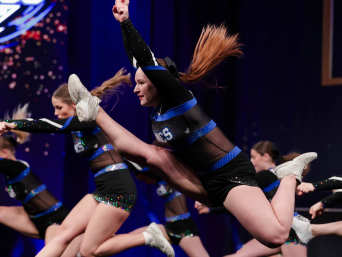 Cheerleading als sport: een cheerleadingteam voert een sprong uit. Cheerleading als sport: een cheerleadingteam voert een sprong uit.