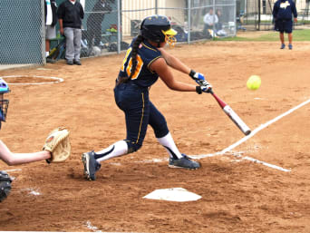 Differenza tra softball e baseball – Giocatrice colpisce una palla da softball con la mazza.