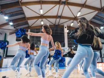 Cheerleading Tipps: Gruppe trainiert eine Tanz-Choreographie mit Pompons.
