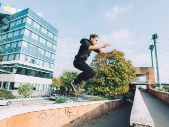 Parkour lernen: Mann springt von einem Hindernis zum nächsten. 