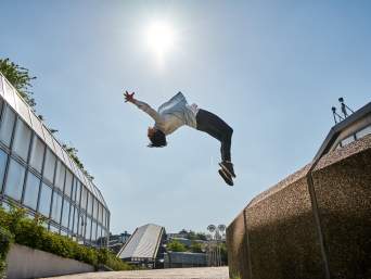 Parkour als Sport: Frau führt einen Salto durch. Parkour als Sport: Frau führt einen Salto durch.
