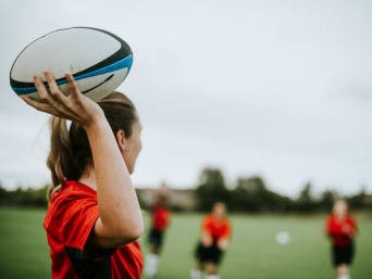 Rugby Anfänger – Spielerin hält den Ball.
