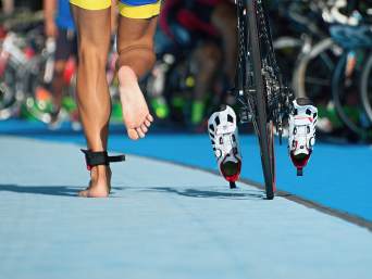 Transizione triathlon: una sportiva si prepara alla sua seconda fase di triathlon. Transizione triathlon: una sportiva si prepara alla sua seconda fase di triathlon.