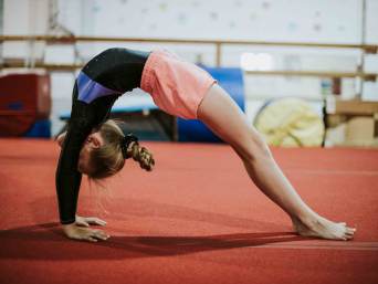 Wat is acro? Een meisje oefent de brug. Wat is acro? Een meisje oefent de brug.