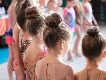 Wat is acro? Een groep van jonge turnsters in wedstrijdkleding. Wat is acro? Een groep van jonge turnsters in wedstrijdkleding.