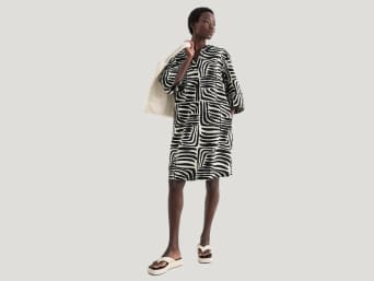 Kaftan – Frau trägt einen Kaftan als Strandoutfit. Kaftan – Frau trägt einen Kaftan als Strandoutfit.