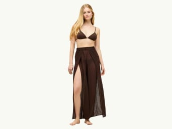 Pantalon de plage long : une femme porte un pantalon à la coupe évasée. Pantalon de plage long : une femme porte un pantalon à la coupe évasée.