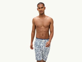 Bade-Boxershorts – Mann in einer Badehose, die bis zur Mitte der Oberschenkel reicht. Bade-Boxershorts – Mann in einer Badehose, die bis zur Mitte der Oberschenkel reicht.