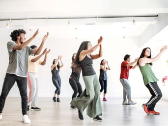 Tanzsport: Tanzgruppe tanzt Zumba in Sportraum.