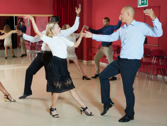 Baile de swing: varias parejas practican una coreografía en una clase de baile.