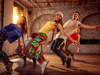 Kleurrijk geklede dansgroep danst hiphop choreografie.