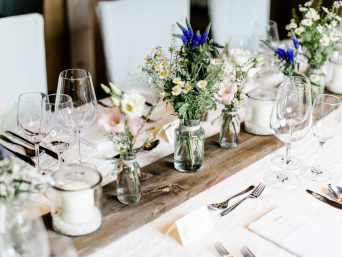 Deko Taufe Ideen – Tischdeko mit Wildblumen und Kerzen.