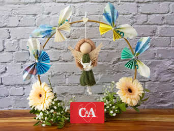 Geldgeschenk basteln Taufe – Blumenkranz mit Schmetterlingen aus Geldscheinen und einem Schutzengel.
