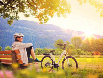Herzroute Etappen: Frau macht Rast auf einer Bank.