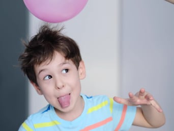Warum Strom sparen – Kind führt ein Experiment zur Elektrostatik mit einem Ballon durch.