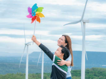 ¿Qué son las energías renovables?: una madre y su hijo experimentan la fuerza eólica con un molinillo de viento.