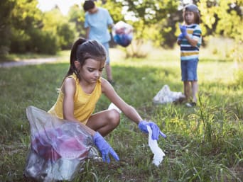 Recycling einfach erklärt: Kinder helfen bei einer Müllsammelaktion im Park. 