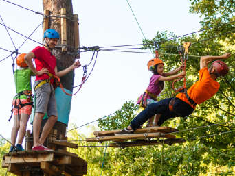 Urlaub mit Kindern im Teutoburger Wald: Familie klettert in einem Kletterpark. Urlaub mit Kindern im Teutoburger Wald: Familie klettert in einem Kletterpark.
