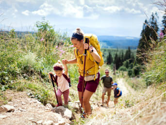 Dónde ir de vacaciones con niños: una familia practicando senderismo.
