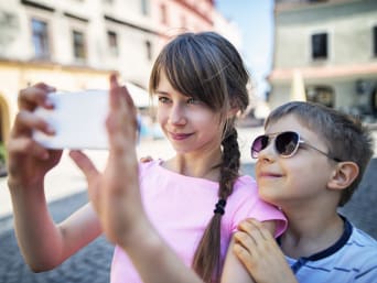 Lublin z dziećmi: rodzeństwo robi selfie na Starym Mieście w Lublinie.