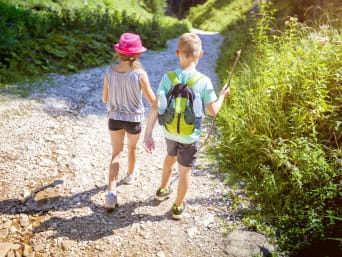 Ausflüge mit Kindern Niederösterreich: Mädchen und Bub wandern auf einem Schotterweg.
