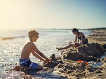 Ostsee Urlaub mit Kindern: Kinder bauen Sandburgen am Strand der Ostsee.