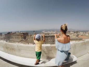 Vacanze famiglia Sardegna: mamma e bambino si affacciano dalla terrazza di Calamosca a Cagliari.