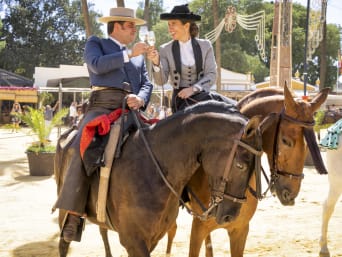 Tipos de vinos de Jerez: una pareja de jinetes en la Feria de Jerez brinda con una copa de vino.