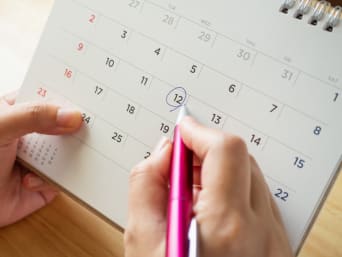 Genussferien: Eine Frau plant ihren Urlaub mit einem Tischkalender.