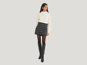 Tenue date femme hiver : pull en tricot et mini-jupe avec des cuissardes.