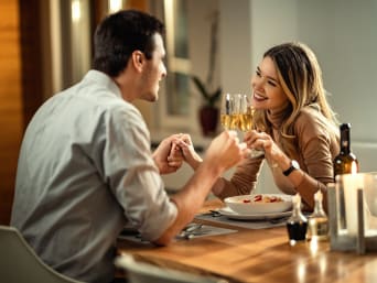 Pomysły na randkę walentynkową: para świętuje na kolacji przy świecach.