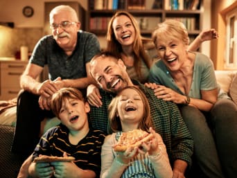 Ideas de regalos para papá: una familia al completo disfrutando de una sesión de cine en casa.